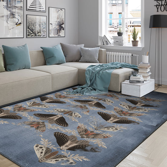 Living room with a blue butterfly-patterned rug on a wooden floor.