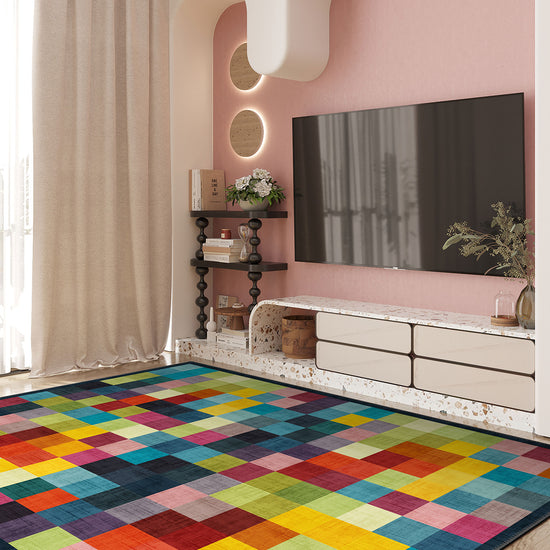 Colorful geometric rug in a living room with a pink wall and TV.