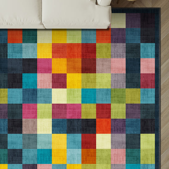 Colorful checkered rug on a wooden floor with a white couch in the background