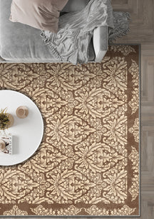 Patterned beige and brown rug in a room with a sofa and small table.