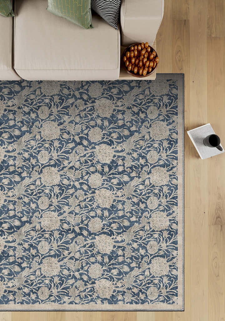 Floral patterned rug on a wooden floor with a sofa and decorative items.