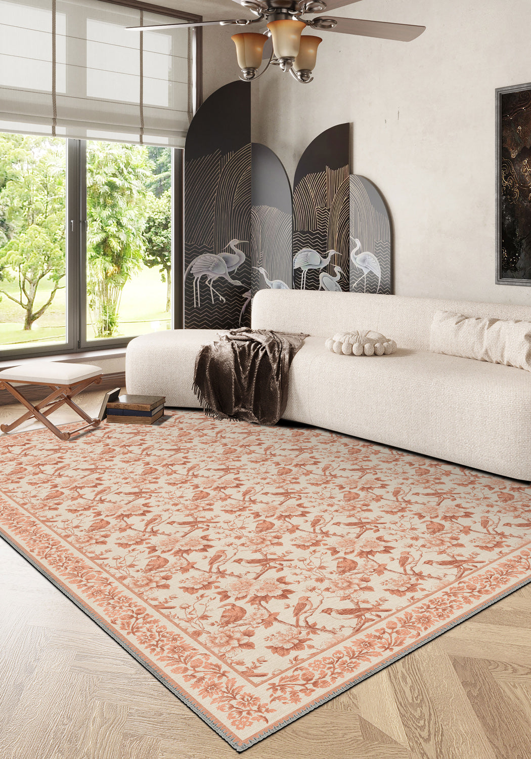Living room with a patterned rug, white sofa, and large windows.