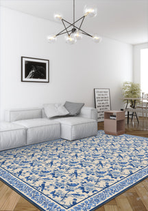 Living room with a blue and white patterned rug, gray sofa, and modern chandelier.