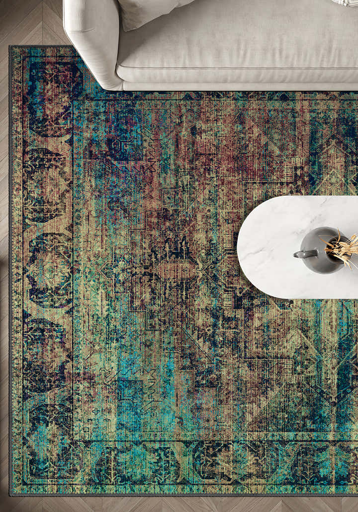 Multicolored patterned rug on a wooden floor with a white chair and table.